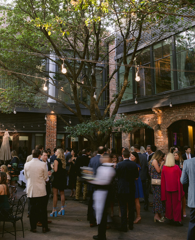 Guests socializing outside at the rehearsal dinner hosted at Brennan's of Houston.