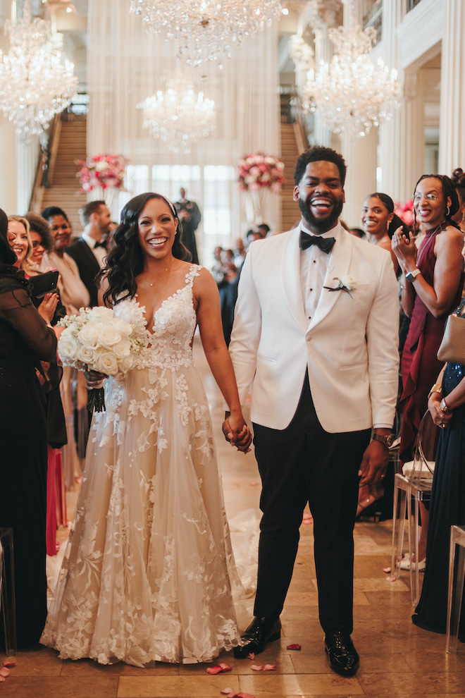 bride in galia lahav gown holds hands with a groom after their wedding ceremony at corinthian houston