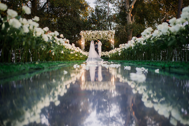 The bride and groom at the altar of their opulent wedding ceremony.