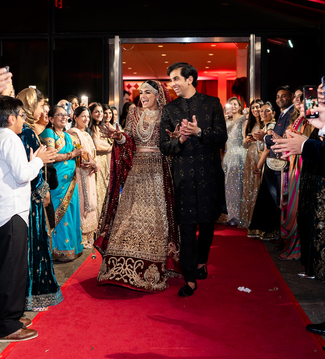 The couple smiling as their guests send them off.