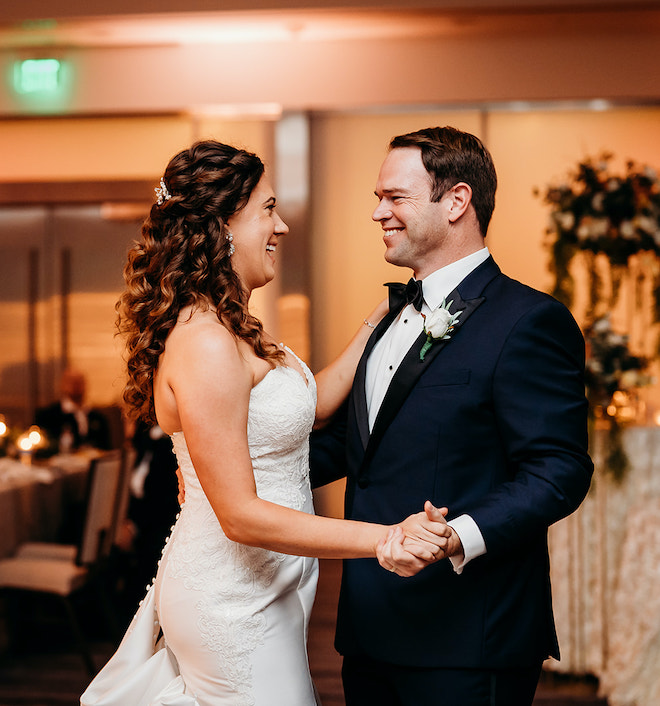 The bride and groom smiling during their first dance.