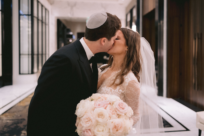 The bride and groom kiss after their wedding ceremony.