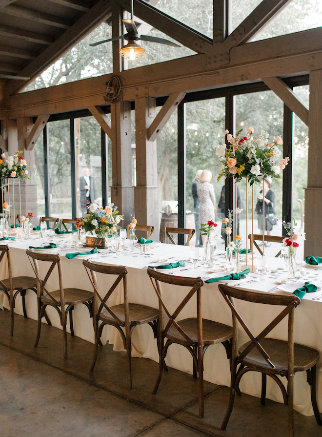 A long reception table in a pavilion used for a wedding reception.