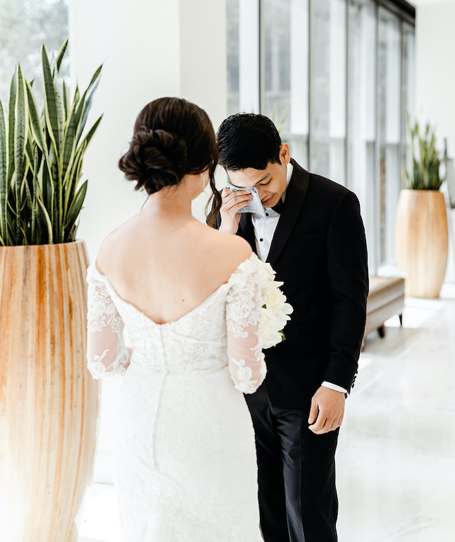 The groom wiping a tear during the couple's first look.