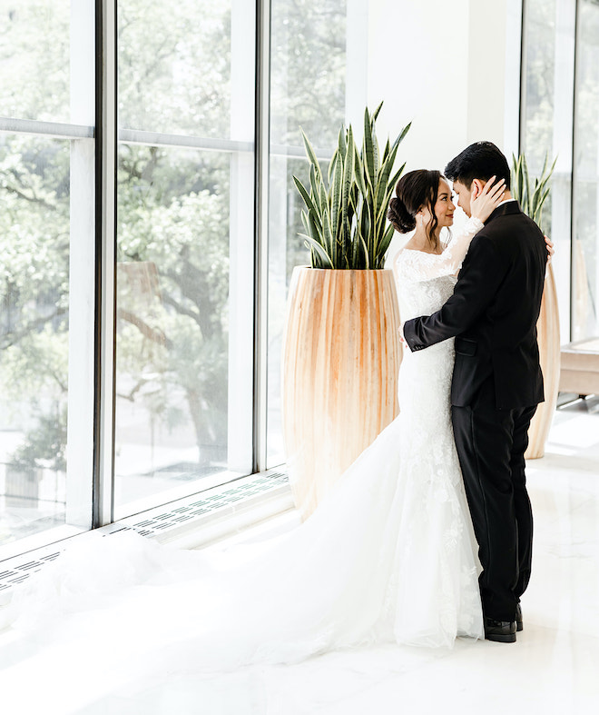 The bride and groom hugging as they look at eachother.