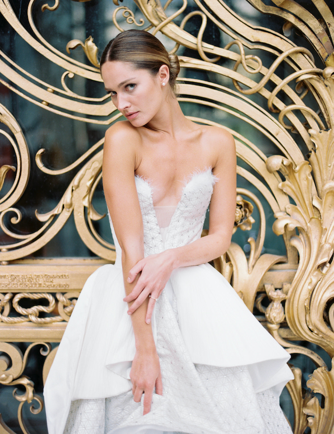 The bride posing in front of a gold iron gate.