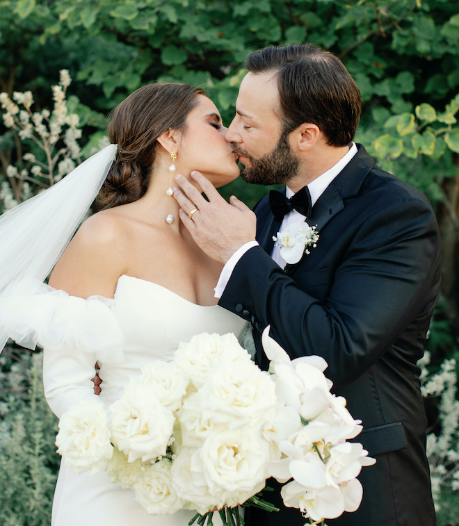 The bride and groom kissing after their wedding ceremony in the San Antonio hill country.