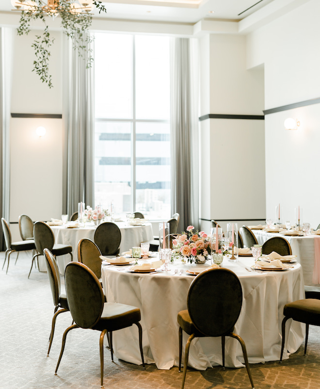 Round tables decorated in the ballroom of the Laura Hotel, a rehearsal dinner spot.