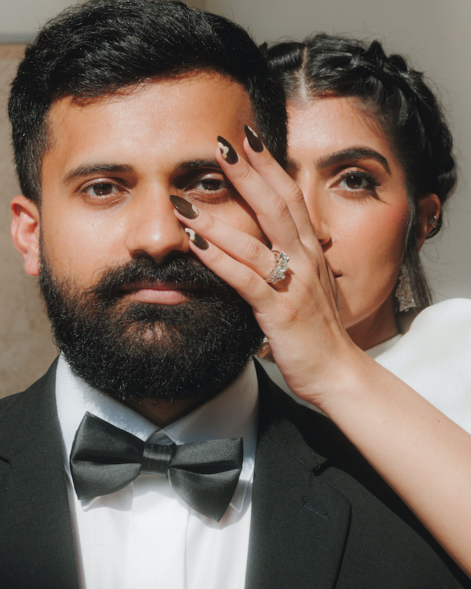 The bride putting her hand on the groom's face, showing off her ring.