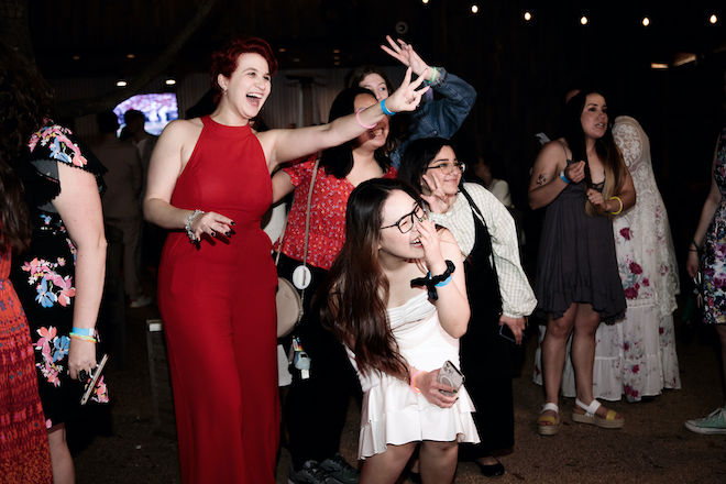 Wedding professionals making peace signs as they smile for a photo.