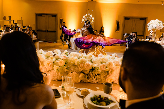 A woman wearing a colorful outfit performing on the dance floor. 