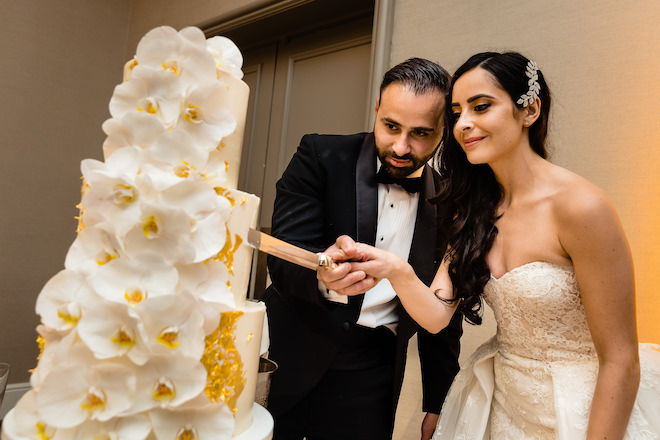 The bride and groom cutting their wedding cake. 