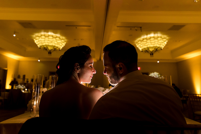 The bride and groom smiling at each other during the reception.