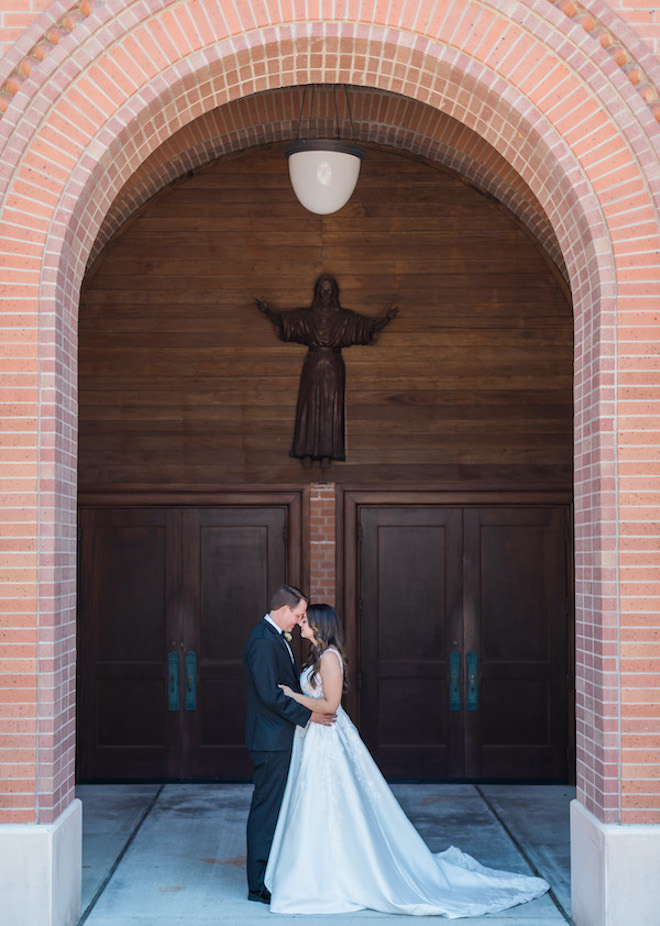 The bride and groom touching foreheads outside the church. 