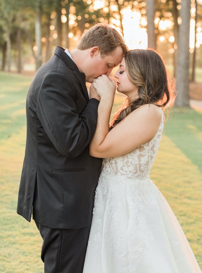 The groom kissing the brides hands. 