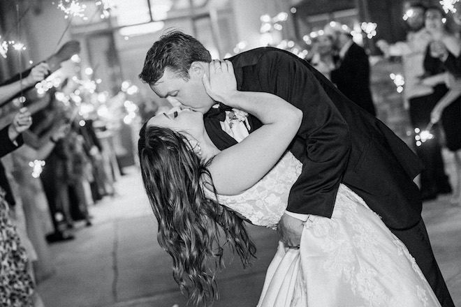 The bride and groom kissing during the sparkler send off. 