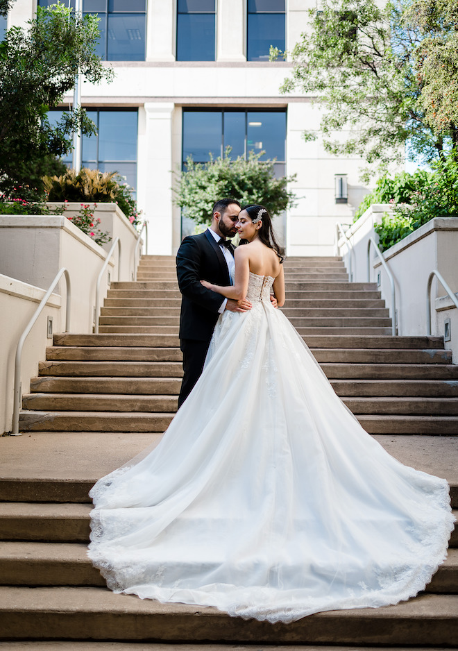 The bride and groom posing on a staircase outside.