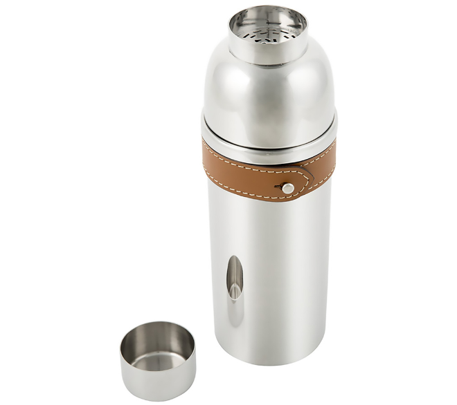 A silver cocktail shaker with a brown leather strap around it. 