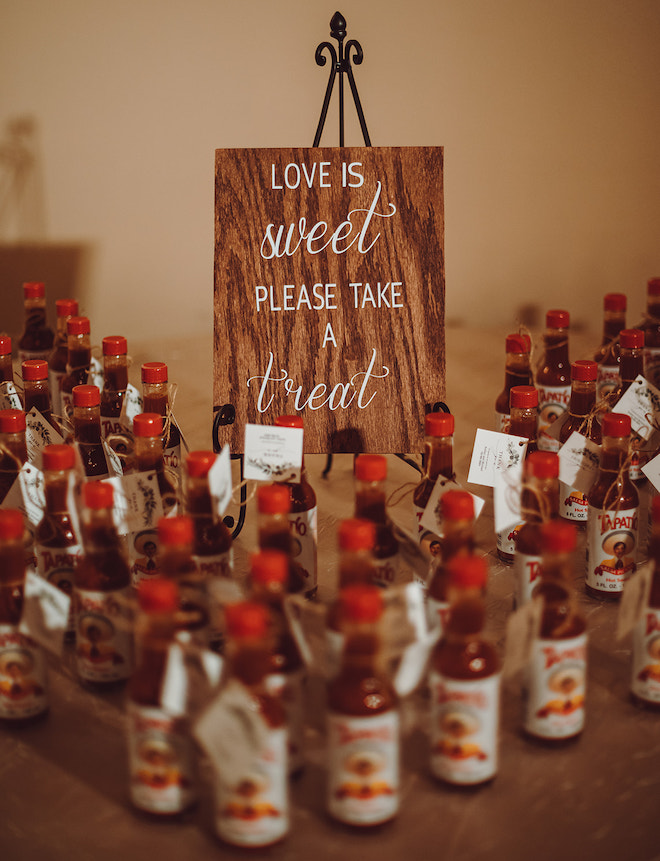 Mini hot sauces with a sign that says "Love is Sweet. Please Take A Treat"