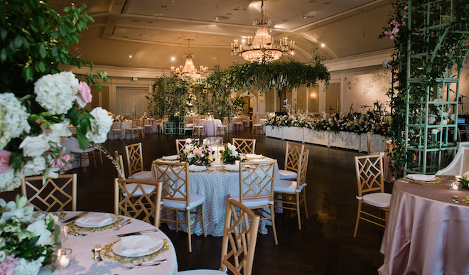 The reception space with circular tables and greenery and florals for a french garden wedding. 