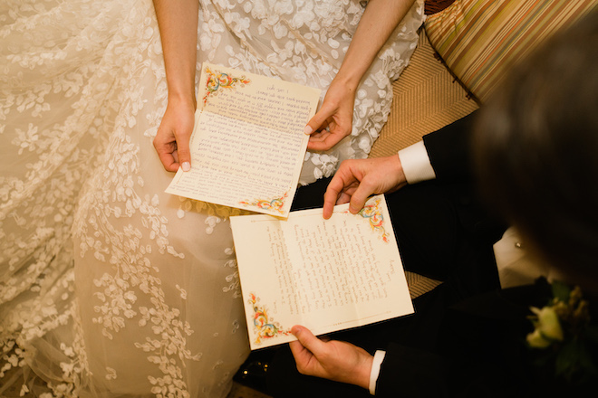 The bride and groom holding their hand-written vows. 