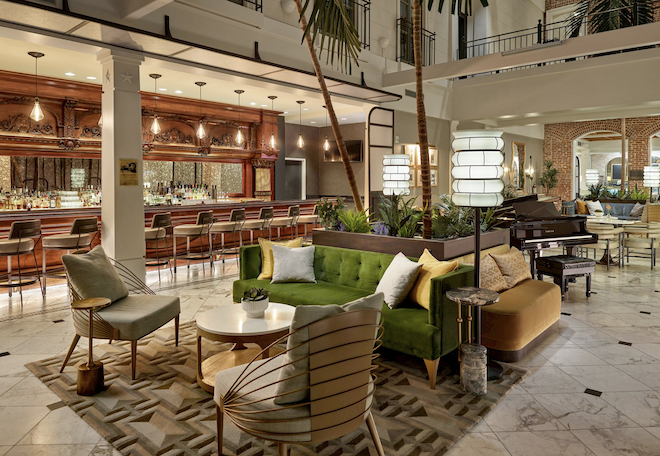 The Toujouse bar with a brown bar and a green couch with modern chairs. 