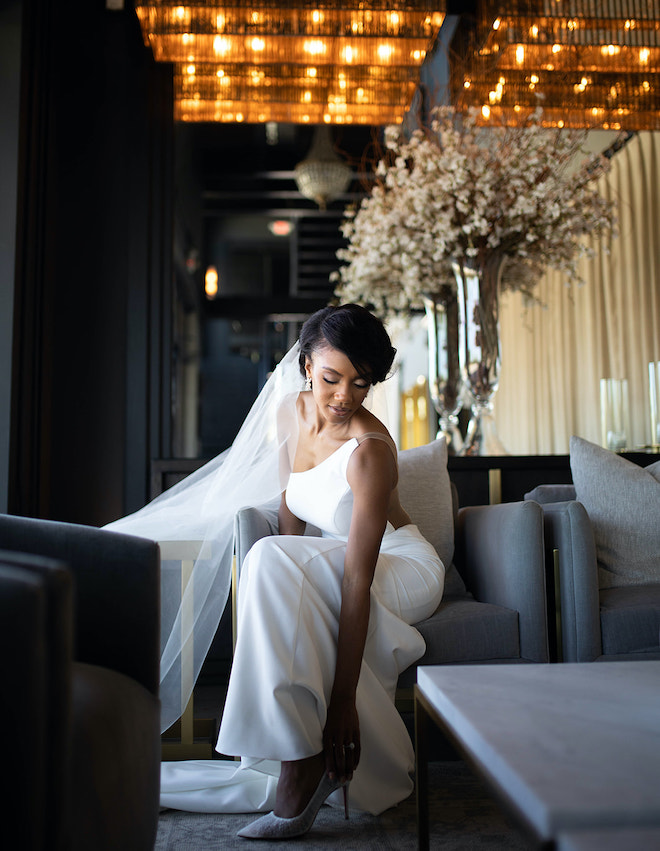 The bride putting on a white heel. 