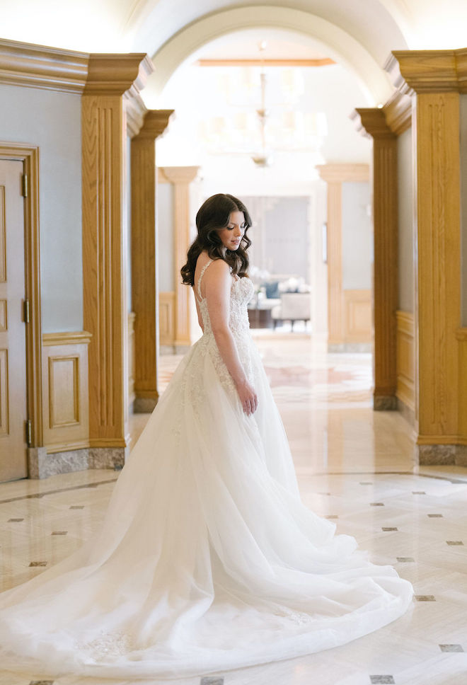 The bride poses in a small atrium of the hotel wedding venue in Houston, Texas. 