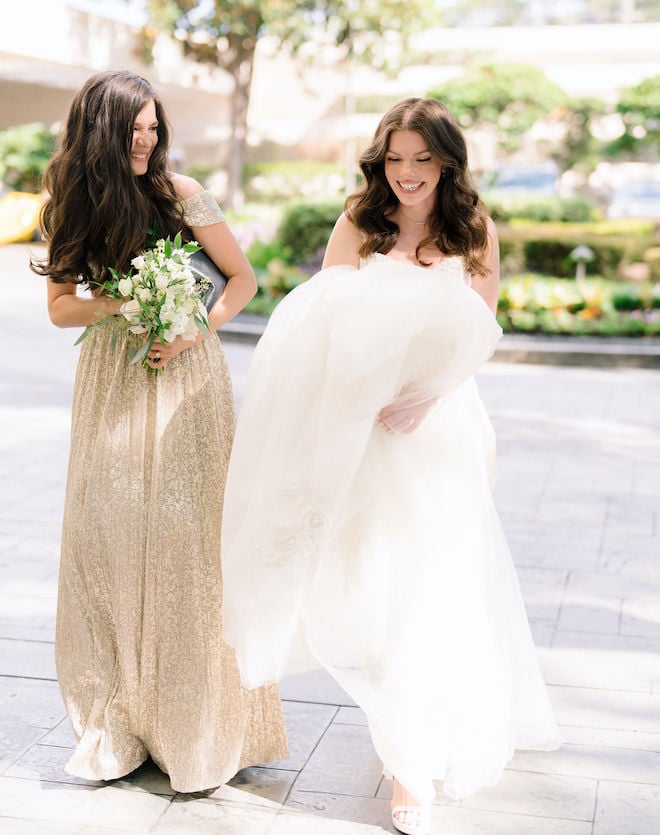 The bride and one of her bridesmaids share a laugh outside of the Houston hotel wedding venue. 