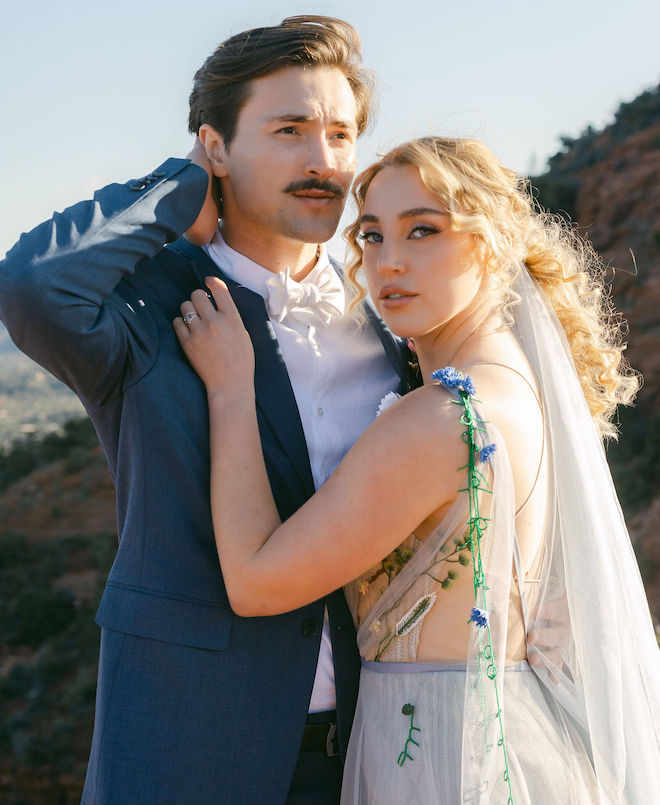 The bride and groom posing for a picture in their wedding attire. 