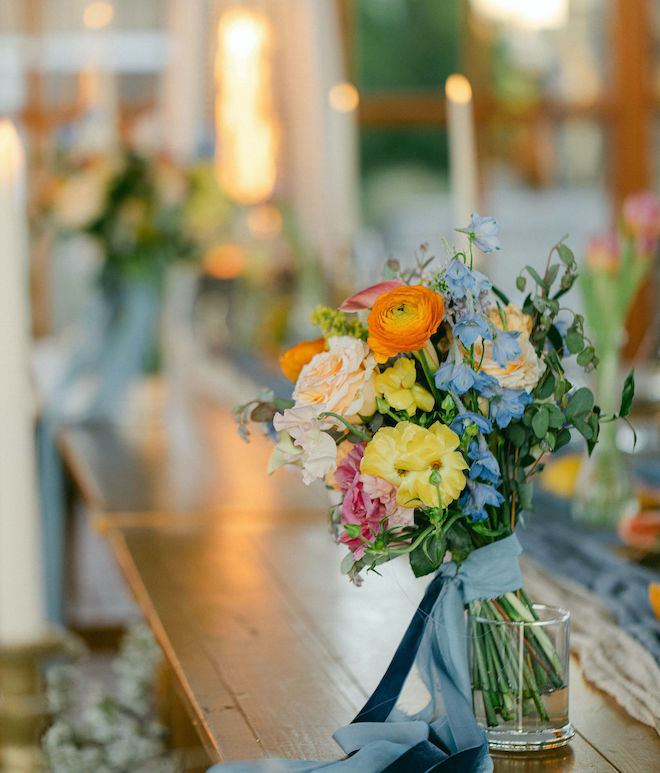 A bouquet of citrus-colored and blue florals. 