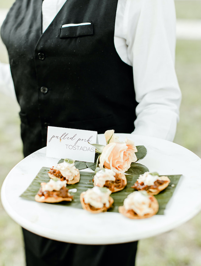 At the cocktail hour, a platter of pulled pork tostadas are served to wedding guests. 