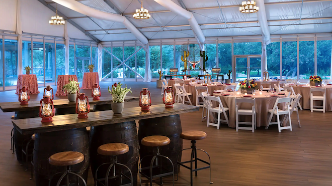 Tented pavilion venue, Roger-Wiseman Pavilion, set up for a wedding reception with chiavari chairs, round banquet tables and two tiered chandeliers.