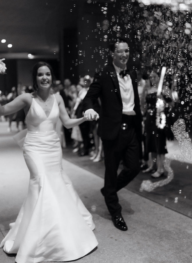 The bride and groom holding hands during their bubble send-off. 