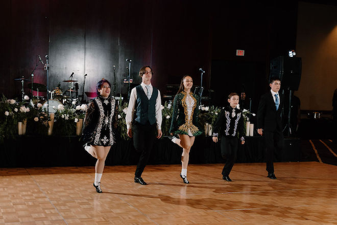 5 dancers performing an Irish Jig on the dance floor. 