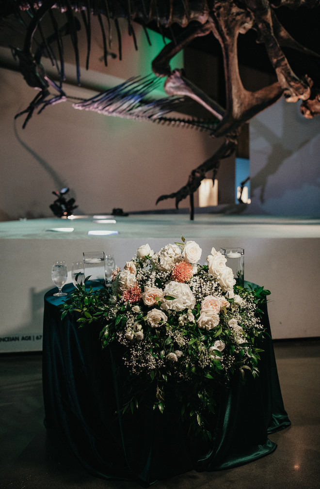 White, pink and greenery decorate the reception tables at the wedding reception. 