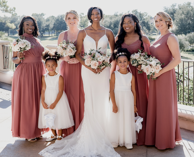 The bride, bridesmaids and flower girls pose outside of the Royal Oaks Country Club before the wedding ceremony. 