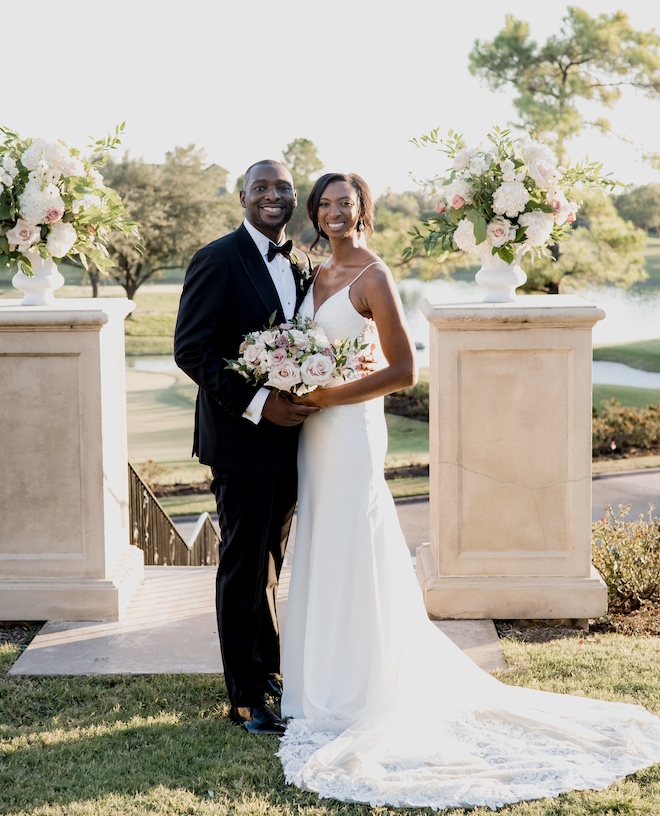 The bride and groom smile outside their wedding venue, the Royal Oaks Country Club.