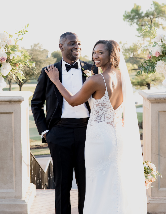 The bride and groom pose smiling at the alter at the outdoor wedding ceremony at Royal Oaks Country Club.