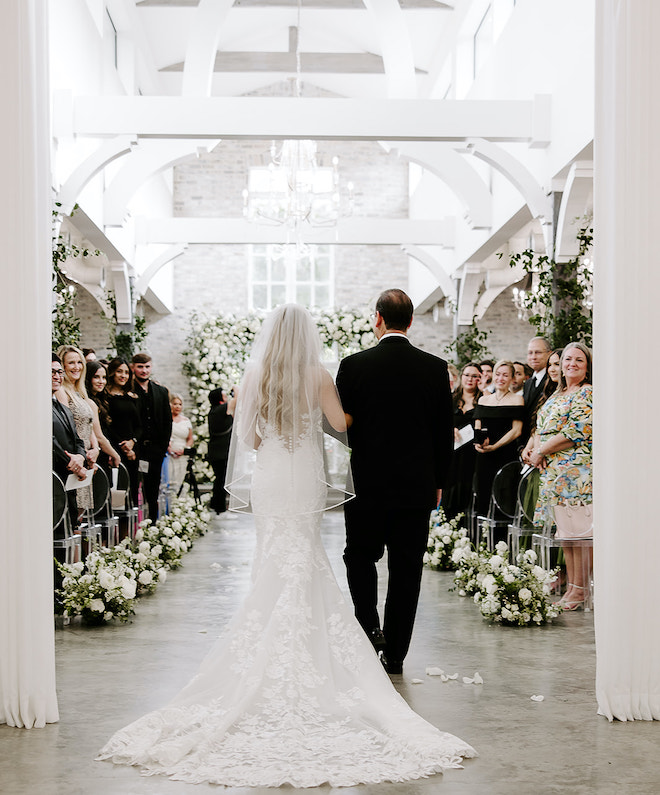 The bride and her dad walking down the aisle. 