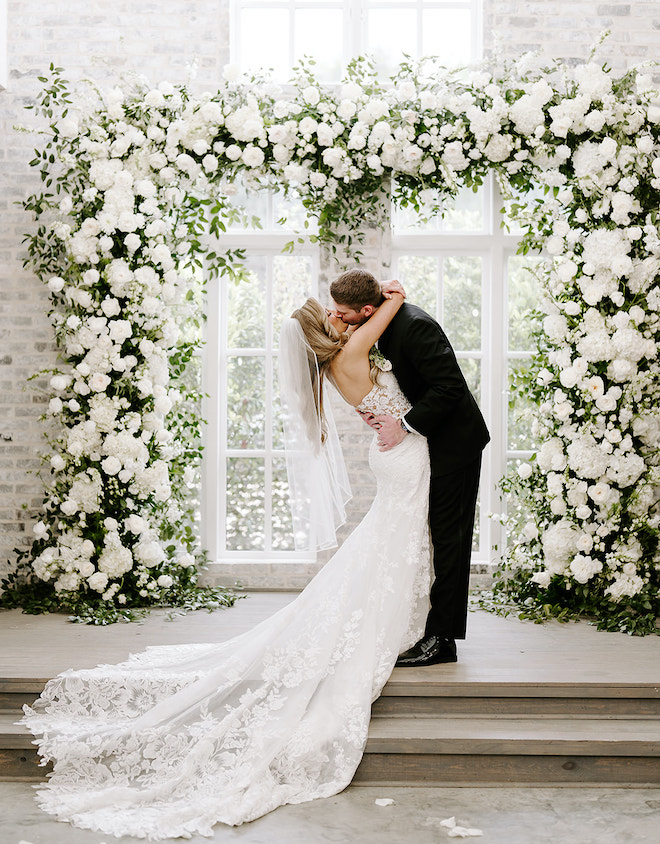 The bride and groom kissing at the altar. 