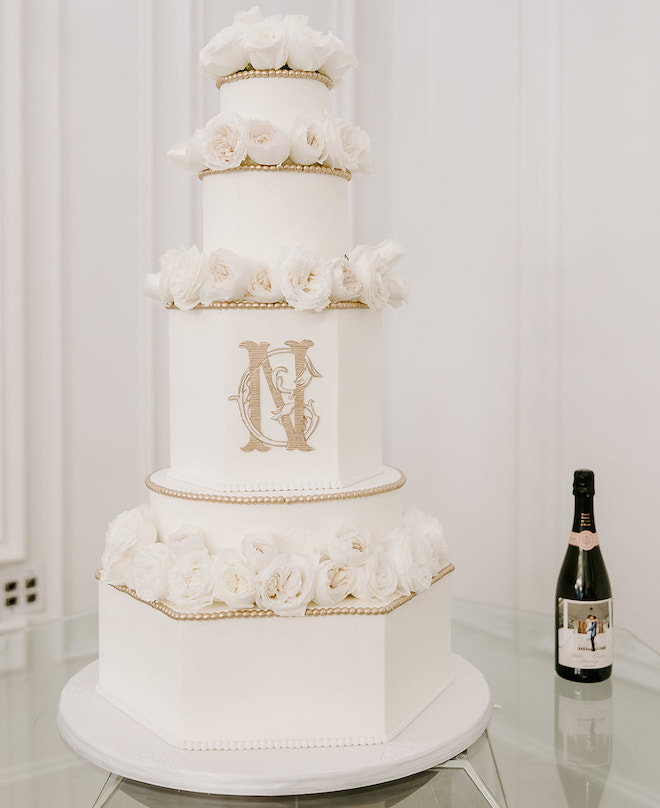 A five tier white cake with gold accents by Cakes by Gina.