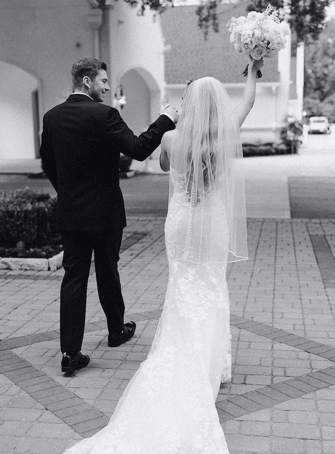 The bride and groom holding hands walking out of the chapel.