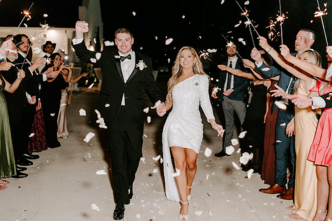 The bride and groom holding hands during their sparkler sendoff. 