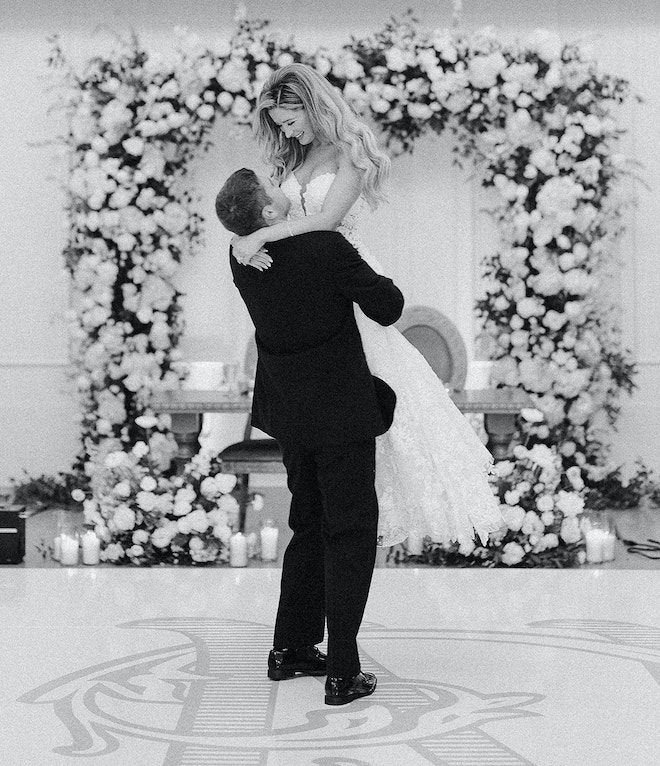 The groom picking the bride up on the dance floor. 