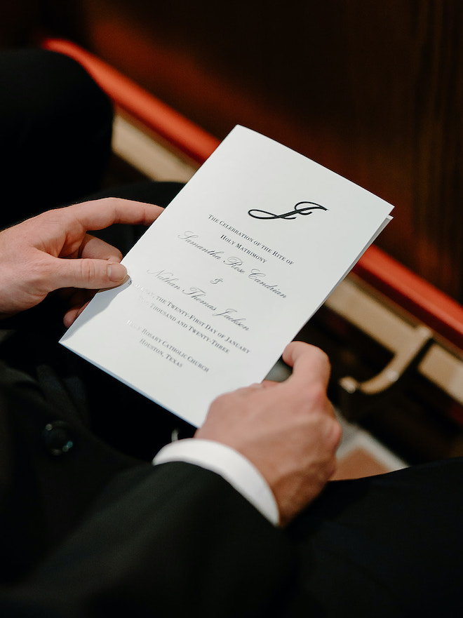 Black and white stationery are passed out to wedding guests for the bride and groom's wedding ceremony. 