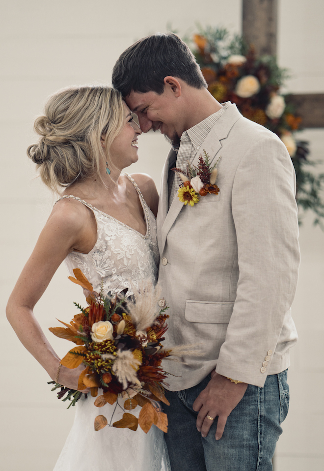 The bride and groom look into each others eyes at the wedding altar. 