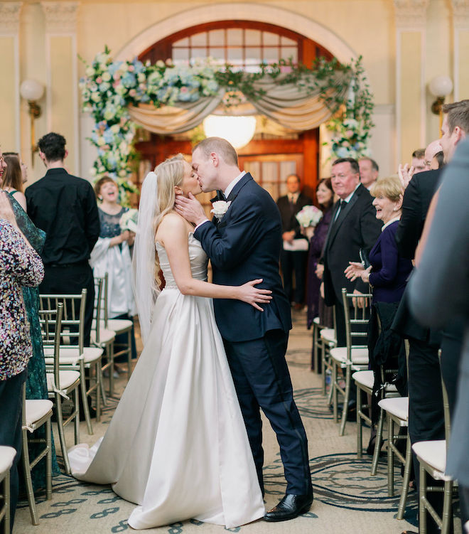 The bride and groom kissing in the aisle. 