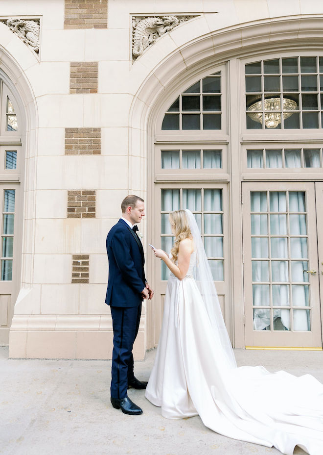 The bride reading her vows to the groom on the balcony of the Crystal Ballroom at the Rice. 