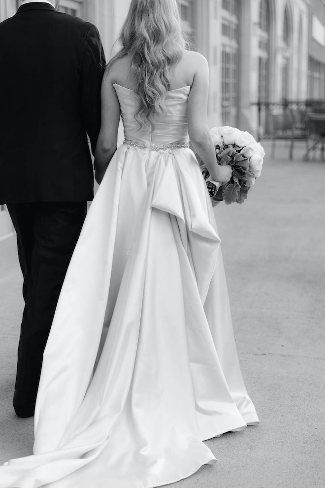 The bride and groom walking from behind on the balcony of Crystal Ballroom at the Rice. 